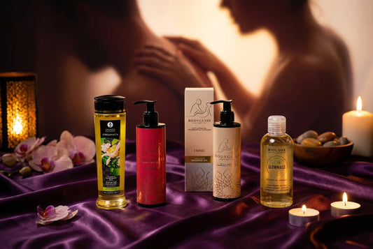 Erotische massage oliën collectie gepresenteerd op een sfeervolle achtergrond met kaarsen en warme tinten voor romantiek