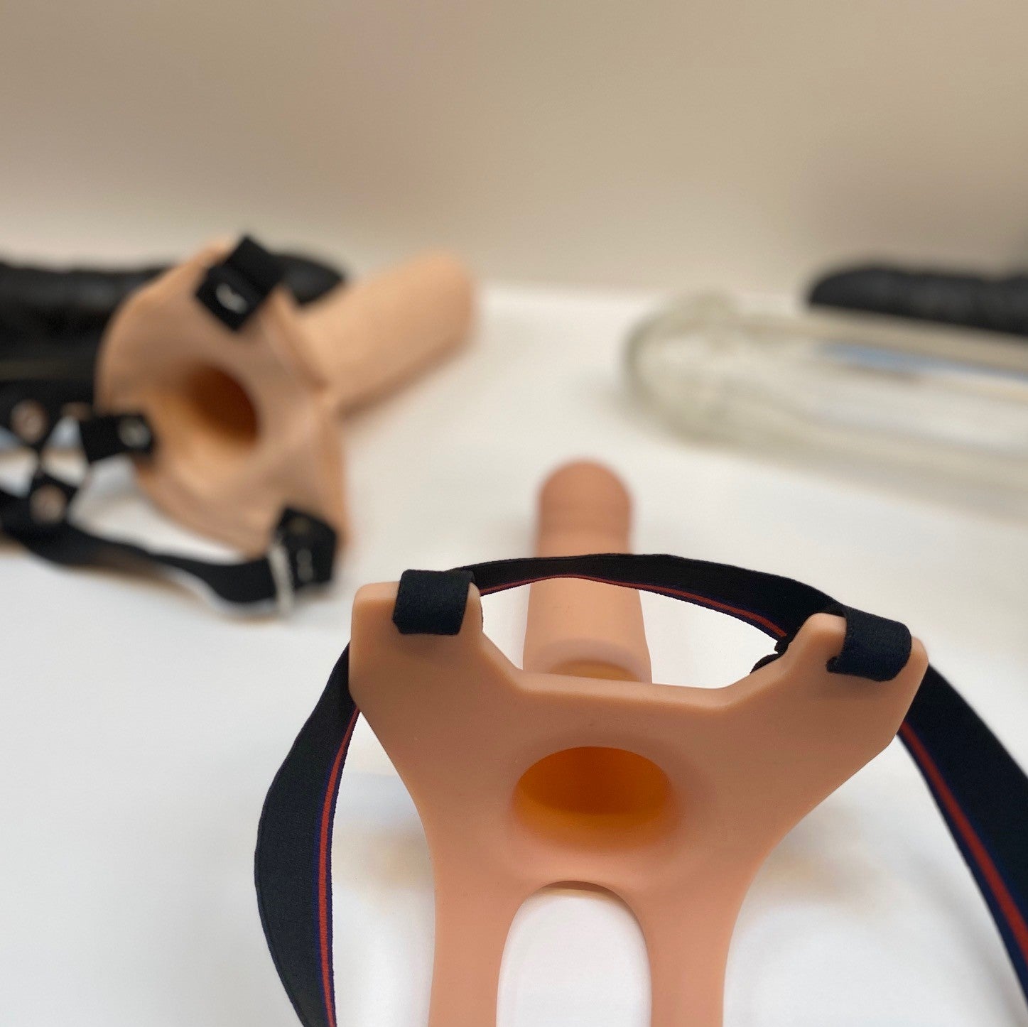 Strap-on harnas en dildo producten gepresenteerd op een neutrale achtergrond voor overzichtelijke productfotografie